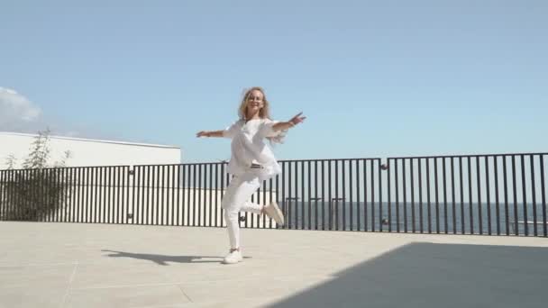Jong meisje dansen en draaien rond in de stad — Stockvideo