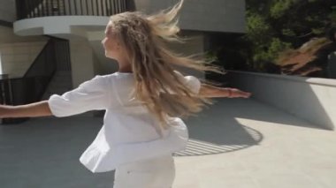 Youngster girl dance and spin around in city