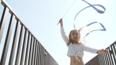 Teen girl making rhythmic exercise with gymnastic tape