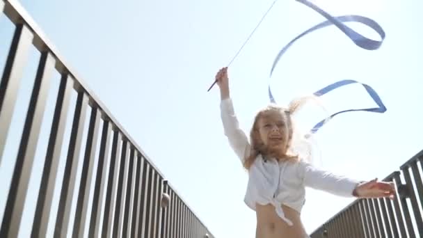 Девочка-подросток делает ритмичные упражнения с помощью гимнастической ленты — стоковое видео