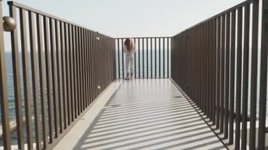Youngster girl sitting in split near metal fence