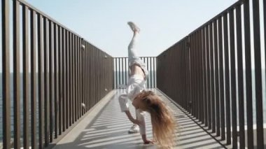 Küçük kız tekerlek yapıyor ve eğleniyor.