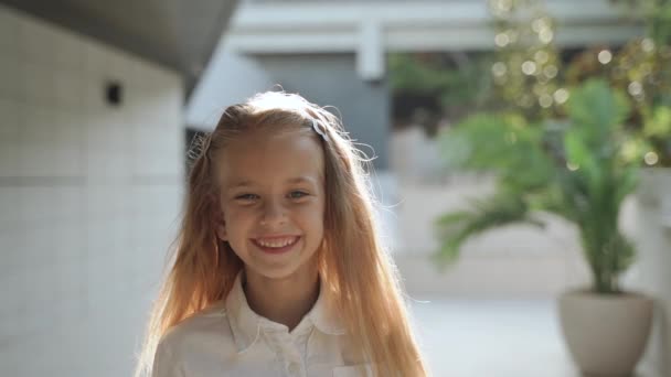 Fiatal lány széles mosollyal, szemben áll az építészet háttér — Stock videók