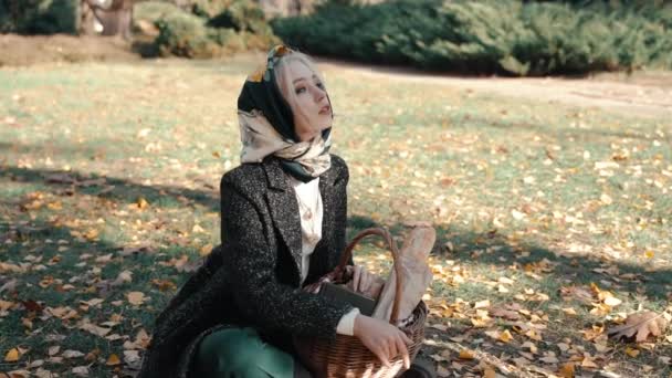 Giovane ragazza adulta seduta nel parco, trascorrere una giornata autunnale all'aria aperta — Video Stock
