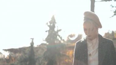 Young adult girl spending sunny autumn day outdoors with smartphone