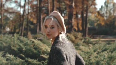 Genç yetişkin bir kadın güneşli bir günde parkta dinleniyor.