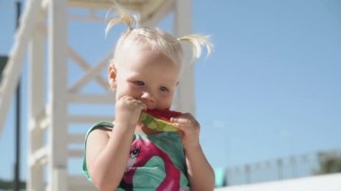 Küçük kız olgun meyve suyu karpuzu yiyor.