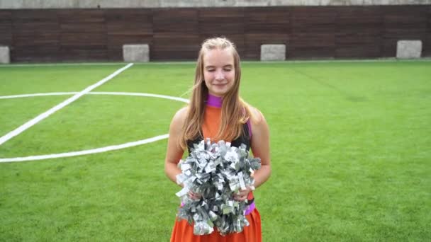 Sporty cheer leader girl in uniform with pom poms support sport team in college — Αρχείο Βίντεο