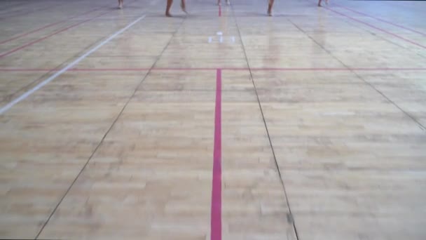 Девочки-подростки в форме чирлидеров с помпонами поддерживают баскетбольную команду колледжа — стоковое видео