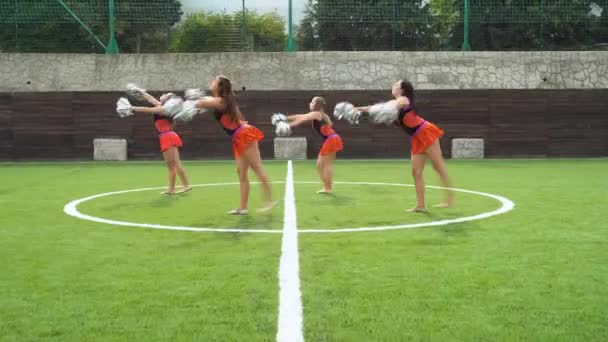 Animar a las niñas líderes en uniforme con pompones apoyo equipo deportivo en la universidad — Vídeos de Stock