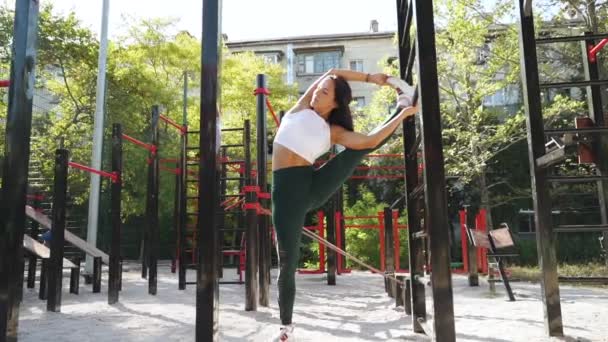Jeune fille sportive adulte s'entraînant à l'extérieur, faisant de l'exercice de flexibilité — Video