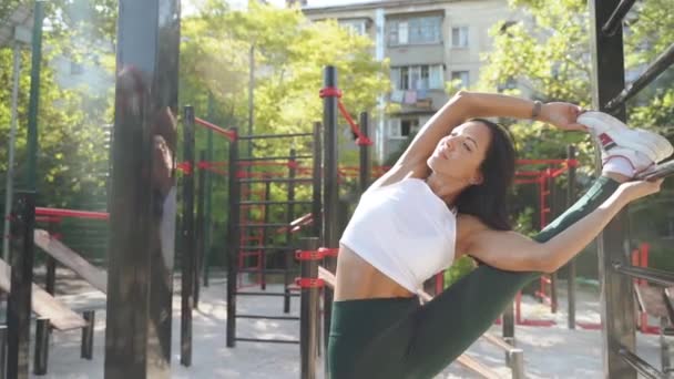 Jovem mulher desportiva adulto em pé e alongamento ao ar livre — Vídeo de Stock