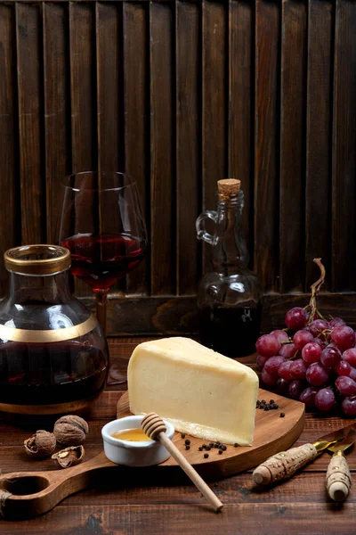 Pedaço de queijo parmesão servido com uva e vinho — Fotografia de Stock