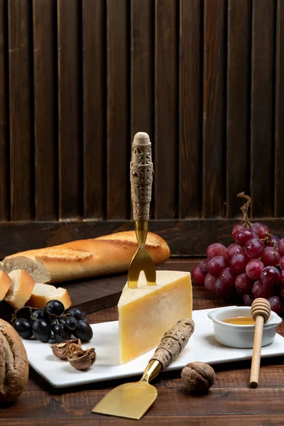 Сыр пармезан кусок с вилкой сыра на вершине, подается с — стоковое фото