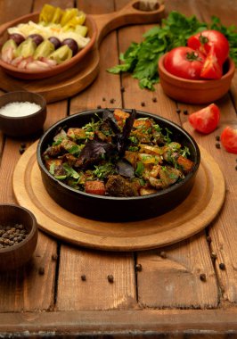 Fırında kuzu eti, taze otlarla süslenmiş dökme demir kasede.