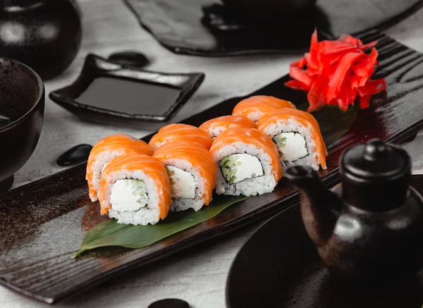 Rouleaux de sushi au concombre recouvert de saumon — Photo