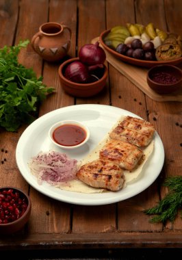 Ketçap ve soğanlı ızgara tavuk parçaları.