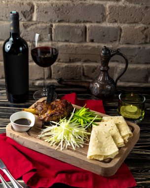 Kırmızı şarapla servis edilen kızarmış kuzu ve lavaş.