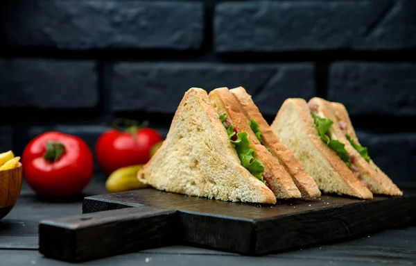 Sandwich club avec pain croustillant sur une planche en bois — Photo