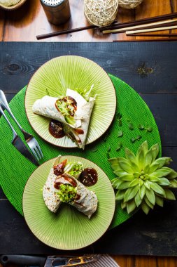 Soya sosuyla servis edilen Çin dürümlerinin üst görüntüsü.