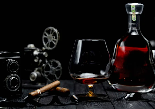 Glass of cognac and cigar on a wooden table — Stock Photo, Image