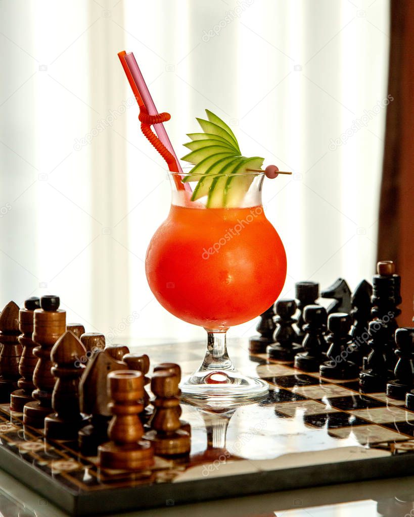 fruit cocktail garnished with apple slices placed on chess board