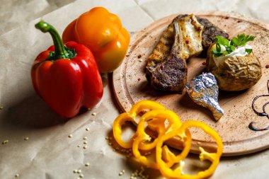 Kuzu pirzolası, tahtadan servis masasında patates ile servis edilir.