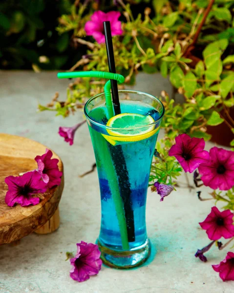 Blue cocktail glass garnished with lemon slice — Stock Photo, Image