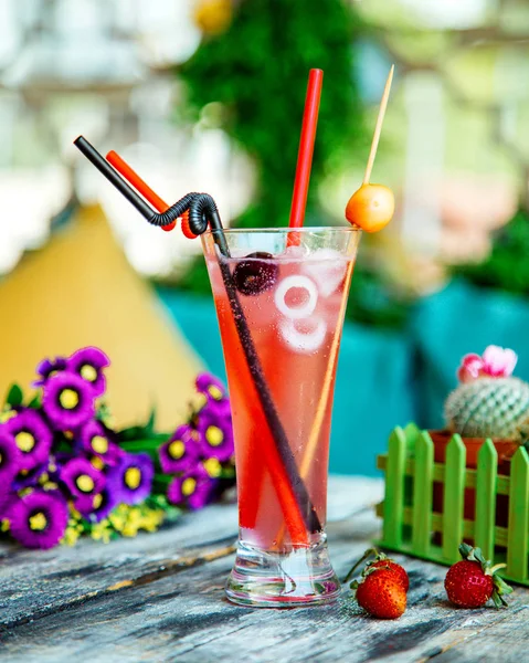 A glass of cherry cocktail with ice and plastic straw — Stock Photo, Image