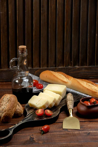 Parmesan slices served on wood board served with baguette — Stock Photo, Image