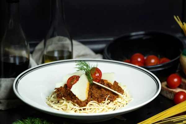 Espaguetis boloñeses adornados con tomates cherry y rodajas de parmesano —  Fotos de Stock