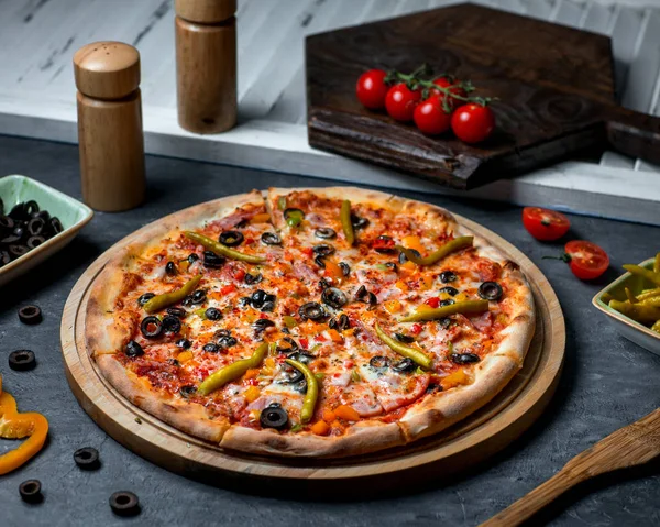 Pizza picante coberto com pimenta e azeitonas — Fotografia de Stock