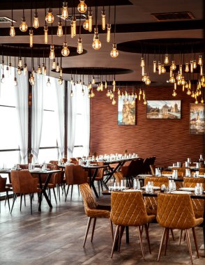 Kahverengi deri sandalyeli, kahverengi duvar kağıtlı restoran salonu.