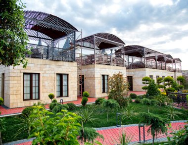 Taş cepheli ve teraslı kır evleri olan restoran bahçesi.