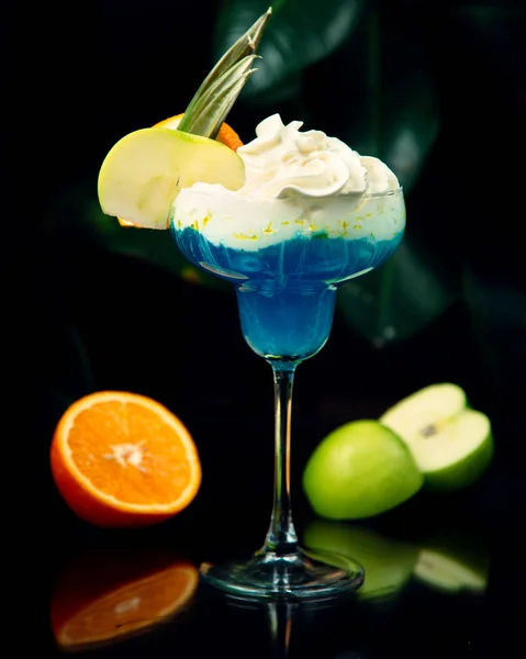 Μπλε κοκτέιλ με σαντιγί και φέτες φρούτων στην κορυφή — Φωτογραφία Αρχείου