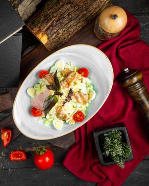 Beyaz kasede tavuklu sezar salatası.