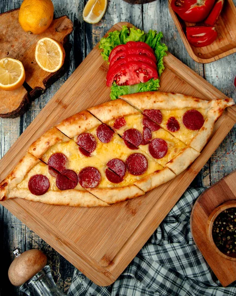 Tahtada dilimlenmiş pide ve sujuk.