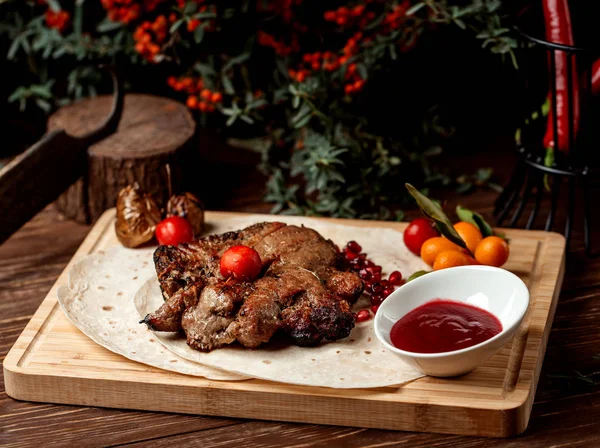 Bife de cordeiro decorado com romã, molho azedo e tomate — Fotografia de Stock