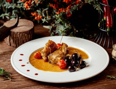 Kiraz ve üzümle servis edilen kızarmış kuzu eti.