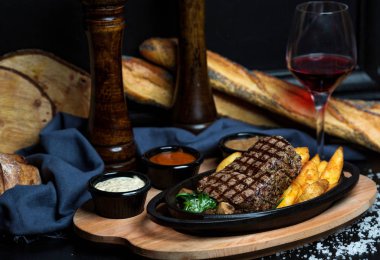 Kızarmış patatesli biftek, mayonez, hardal ve ketçap.