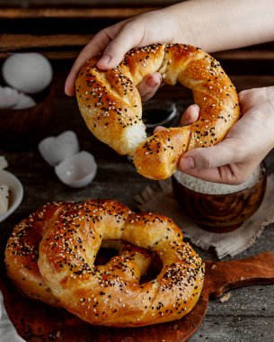 Adam susam ve rezene tohumlarıyla kaplı dairesel hamur işlerini bölüyor.