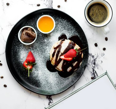 a cup of coffee with pancake in chocolate