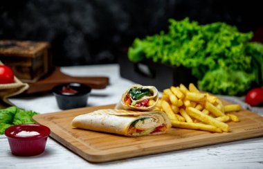 Yanında patates kızartması ve tavuk sarması.