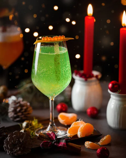 Green sparkling water in christmas table with red candles — Stock Photo, Image