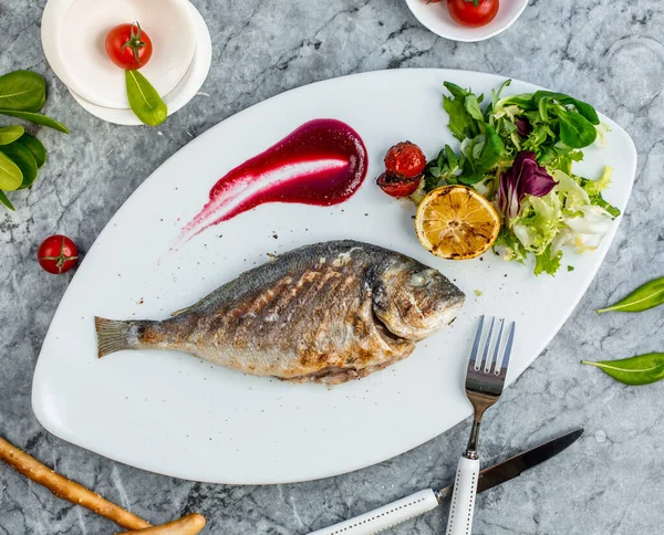 Fried fish with vegetables in the plate ___ — Stockfoto