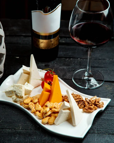 Assiette au fromage avec verre de vin rouge — Photo