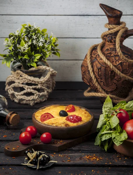 Плавленный сыр с томатными ломтиками и оливками в кастрюле — стоковое фото