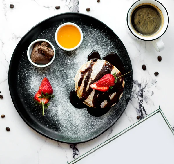 a cup of coffee with pancake in chocolate