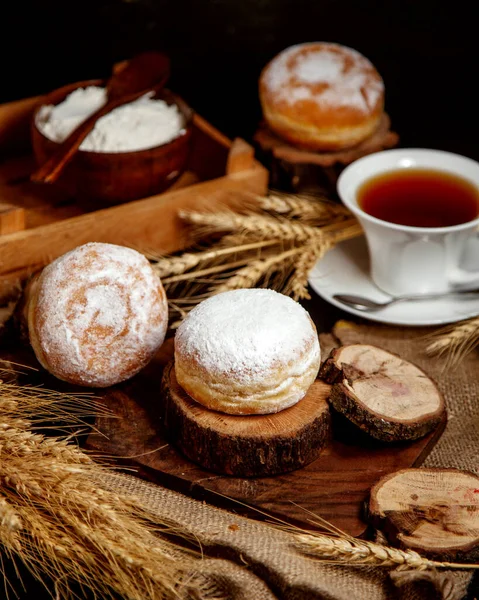 Donuts lisos cobertos com açúcar em pó servido com chá preto — Fotografia de Stock