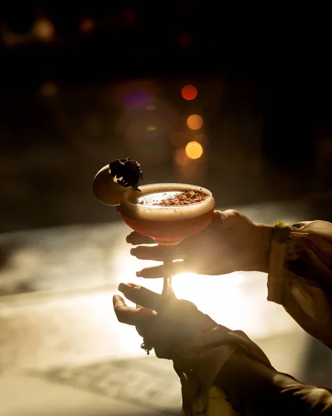 Woman holding  a glass of cocktail in sunset — Stock Photo, Image